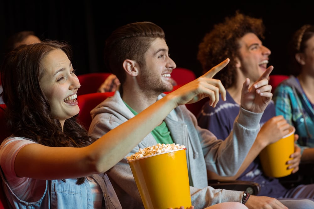 Young friends watching a film at the cinema